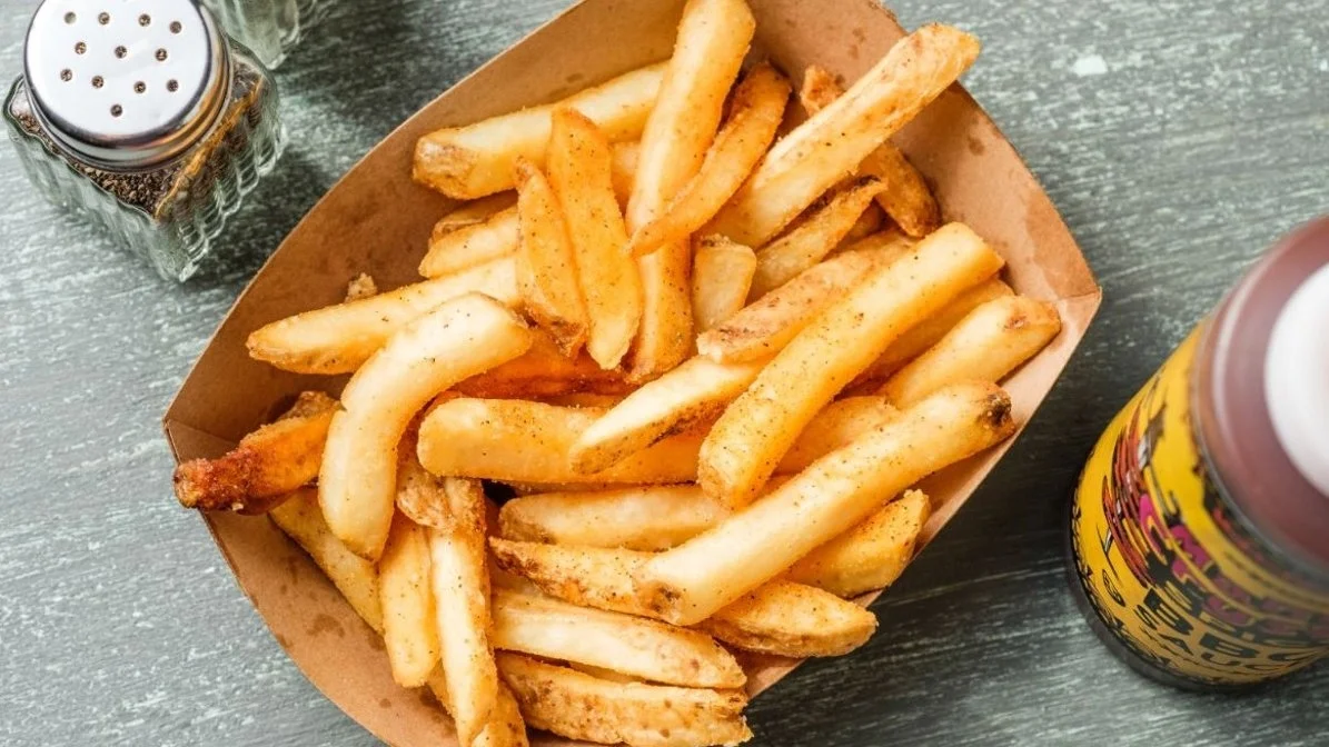 French fries from VooDoo BBQ in Pensacola, seasoned and served as a classic BBQ side.