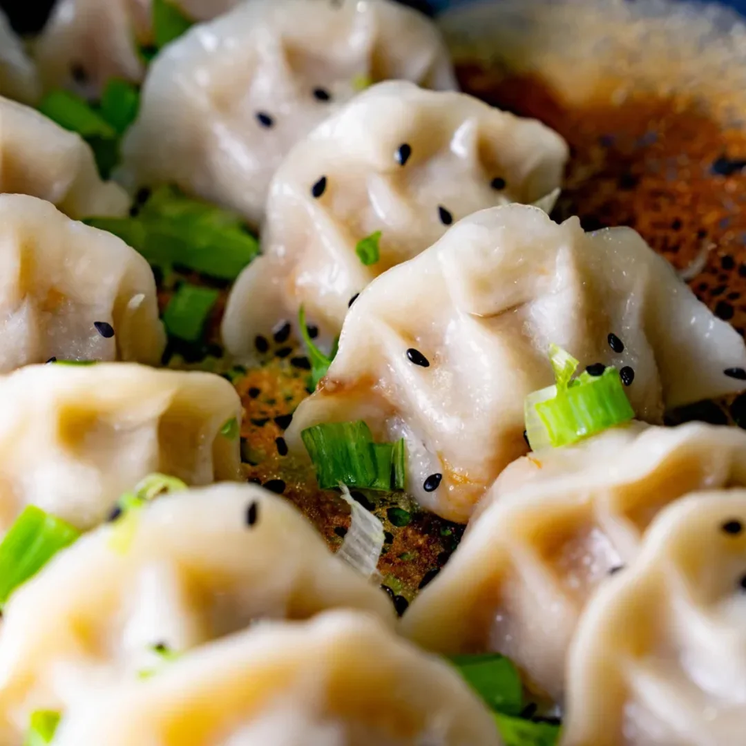 Delicious dumplings garnished with green onions and sesame seeds.