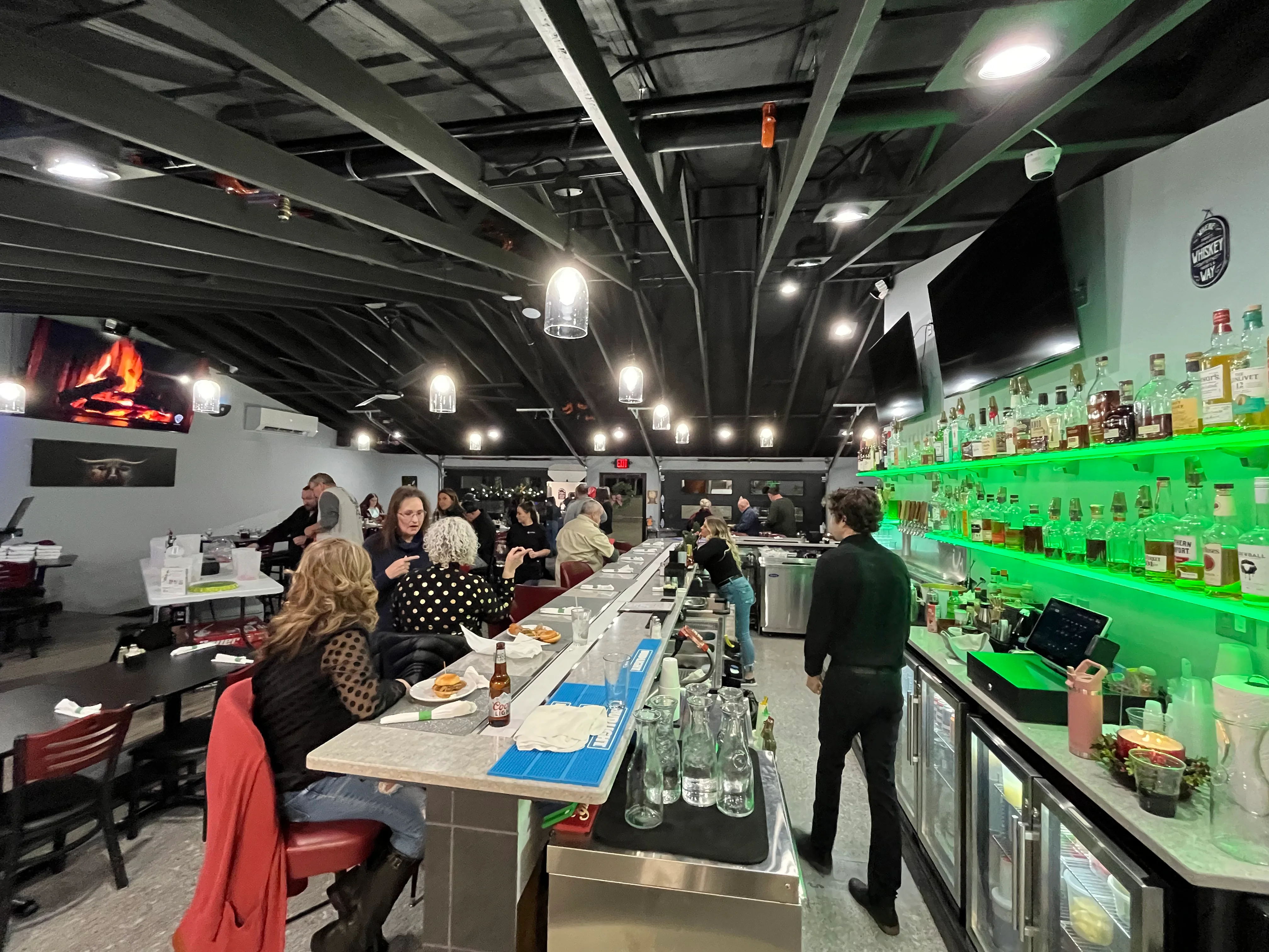 Cozy restaurant interior with bar and patrons enjoying drinks