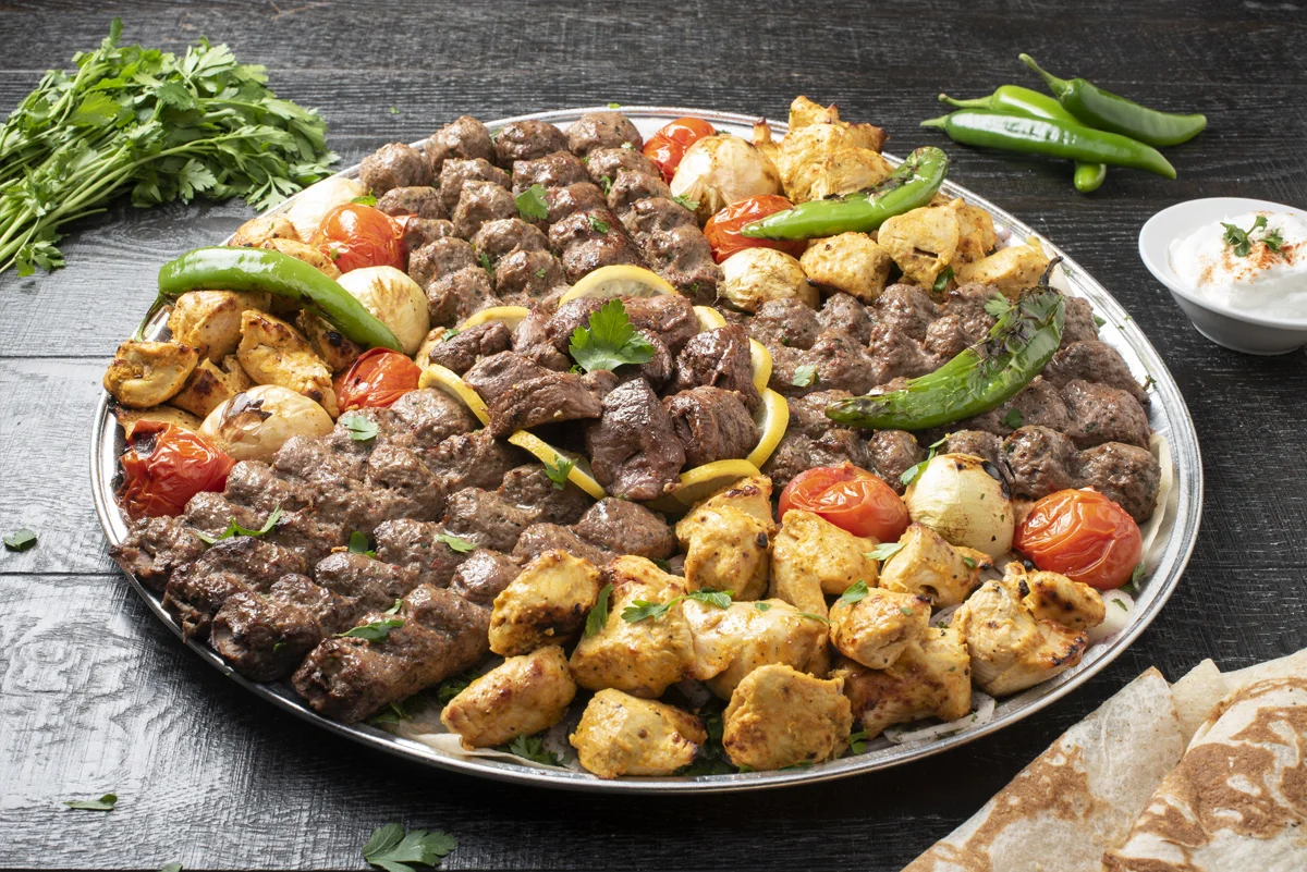 Mixed grill platter featuring kebabs and grilled vegetables