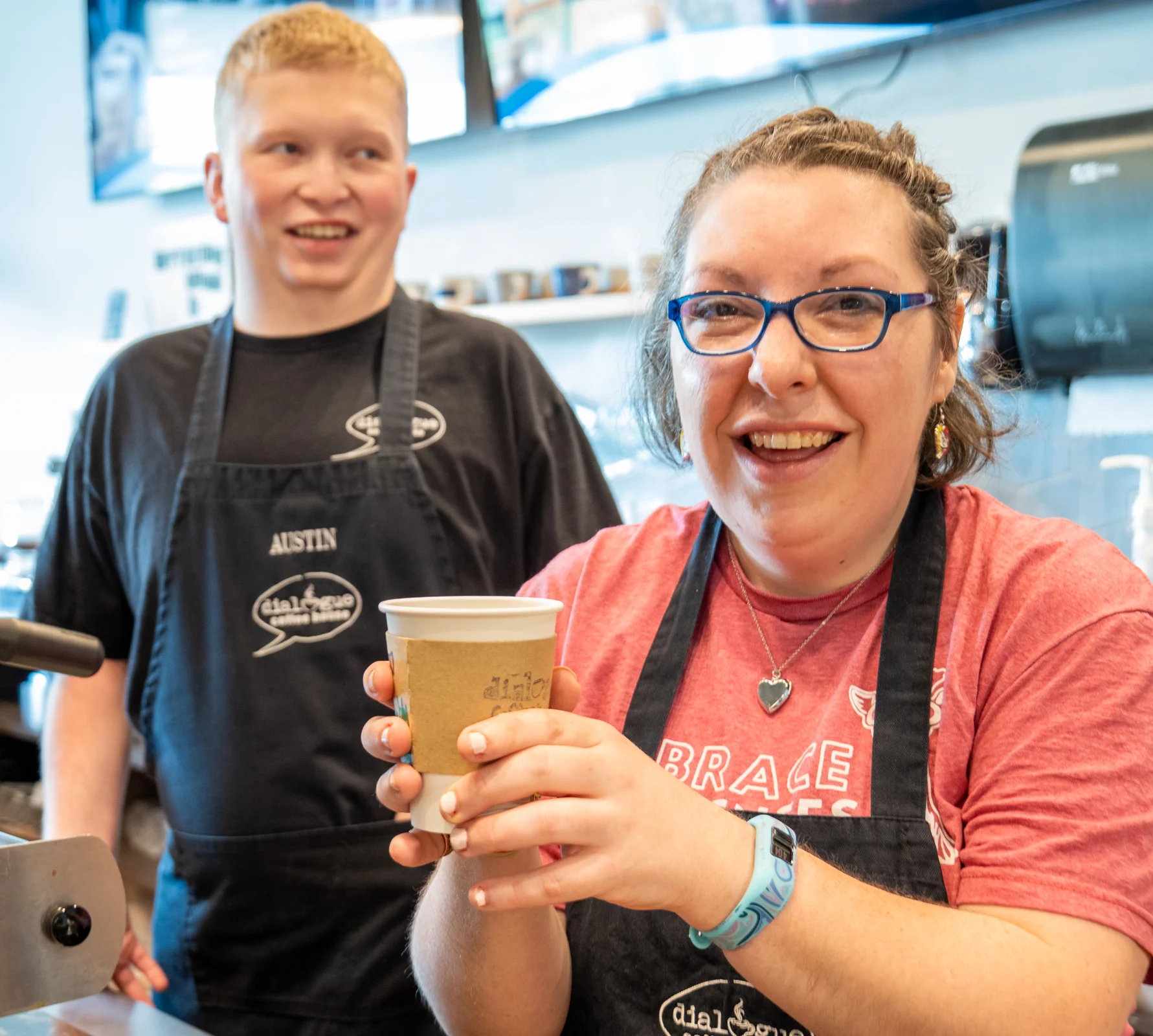 Barista smiling with coffee cup in a cozy café