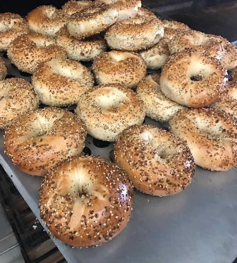 A logo design featuring the name 'Moore Bagels & Coffee Co.' with a tagline indicating it is a neighborhood bagel shop.