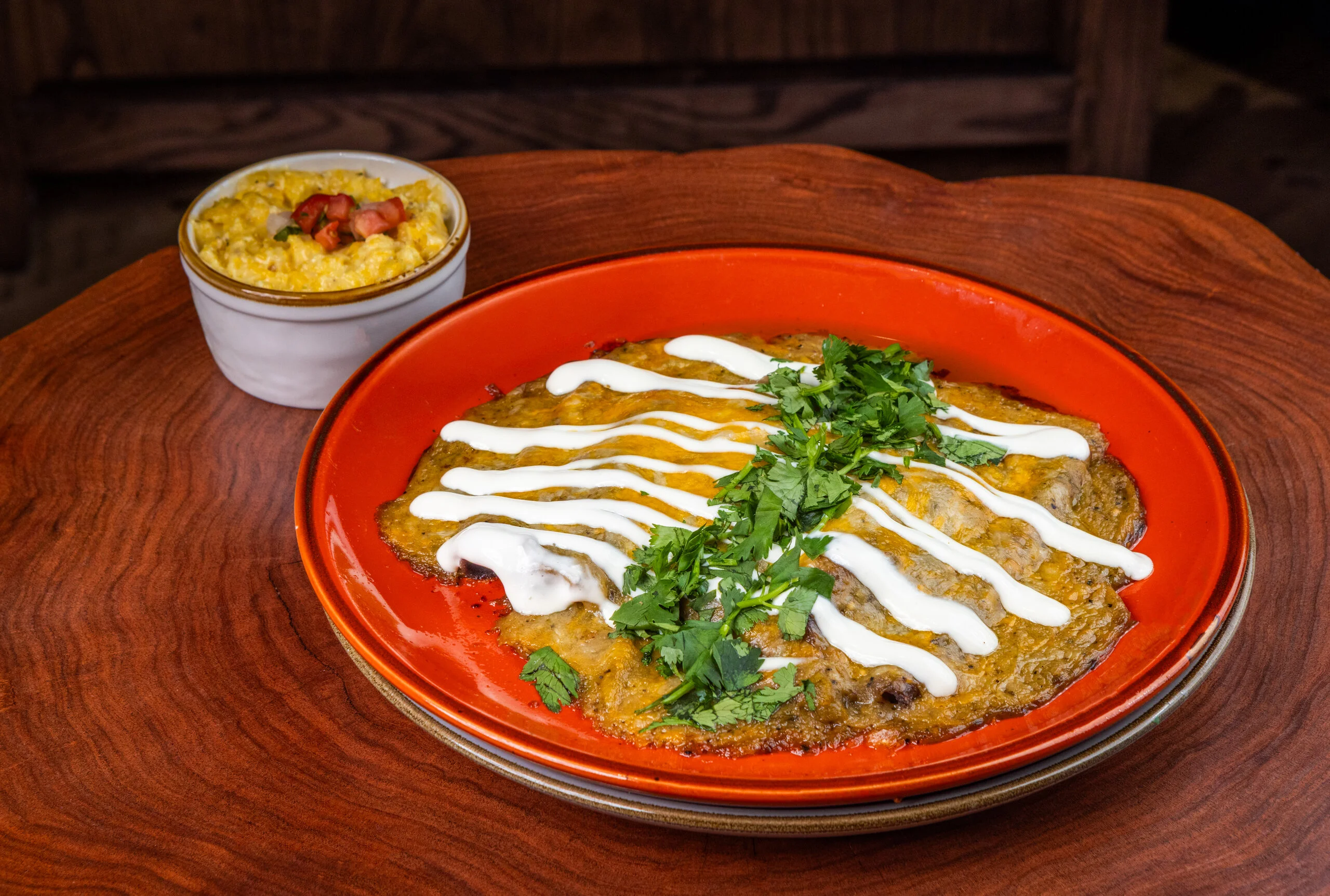 Delicious Mexican enchiladas topped with sour cream and cilantro