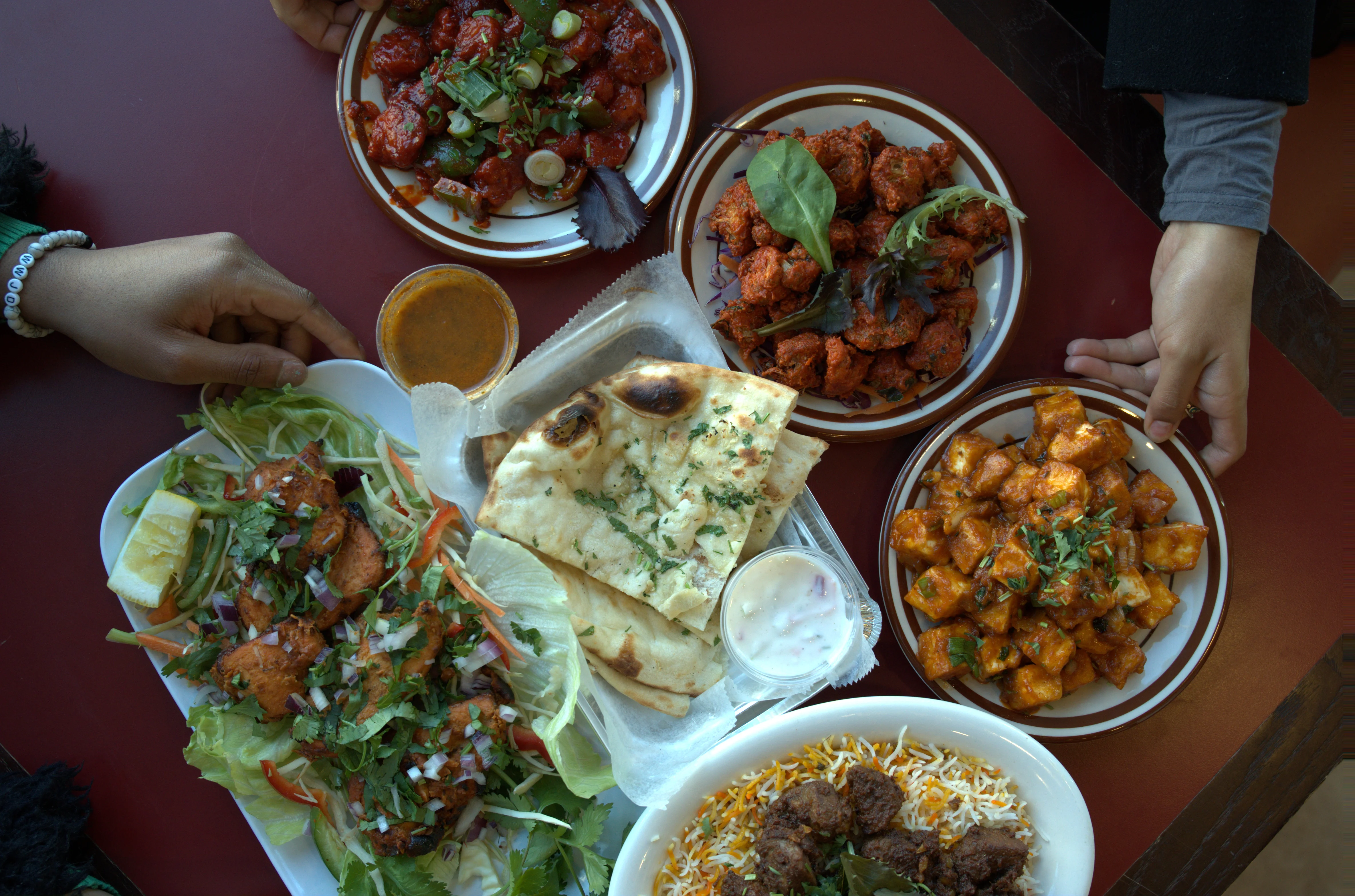 Assorted Indian dishes including naan and paneer tikka