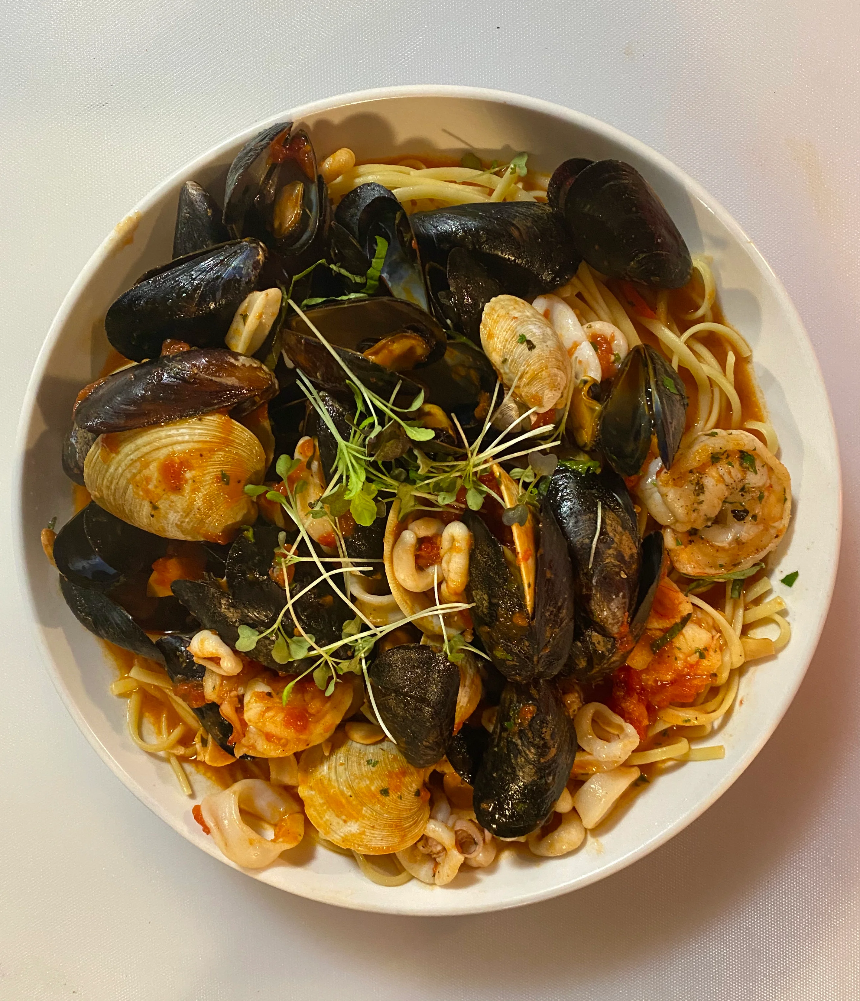 A delicious plate of pasta garnished with herbs and sauce.