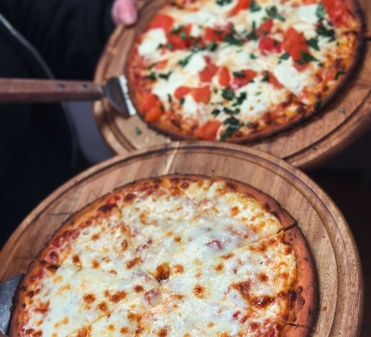 Two delicious pizzas: Margherita and cheese, served on wooden boards