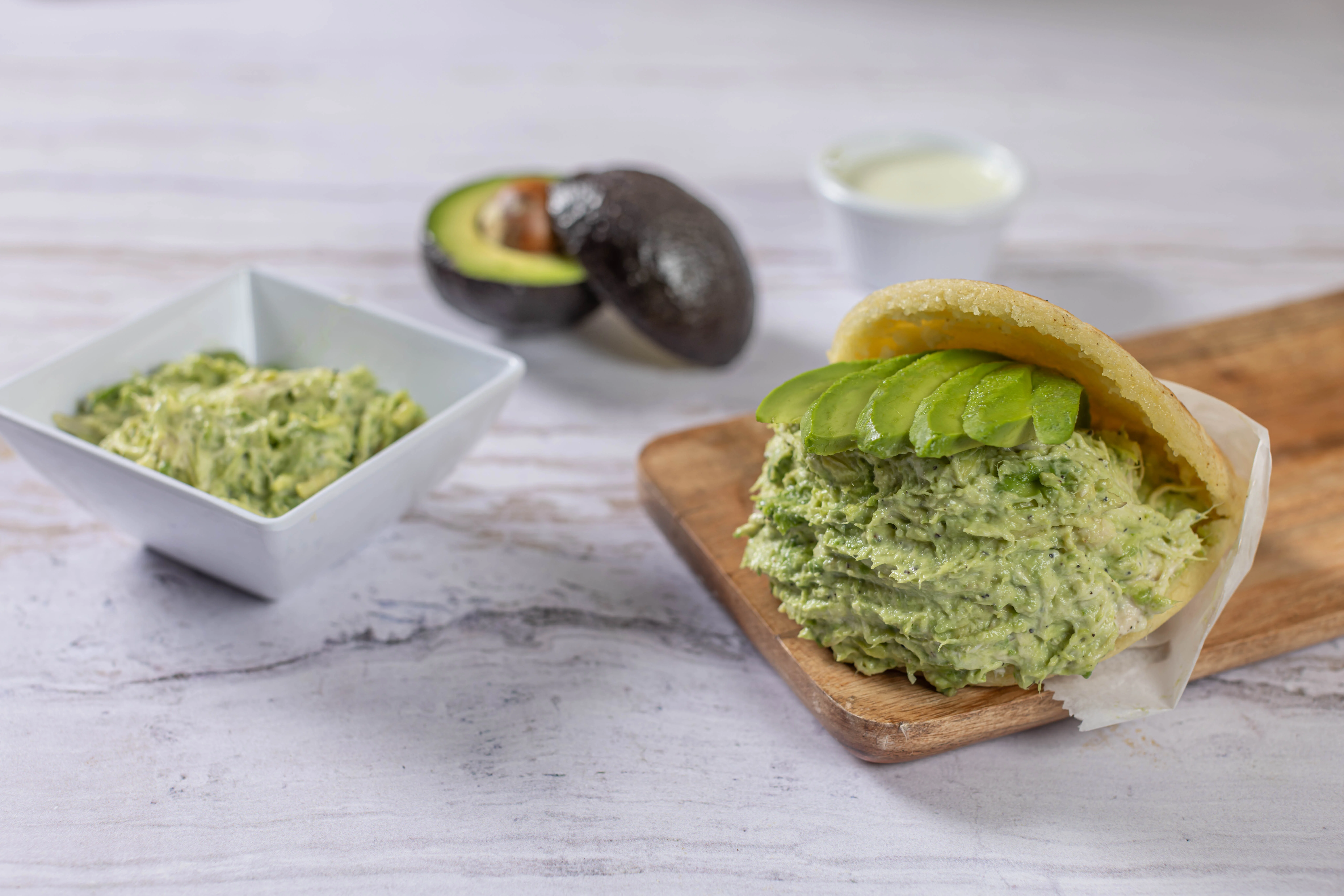 The famous Reina Pepiada arepa from El Budare Cafe, filled with a creamy chicken and avocado salad and topped with fresh avocado slices.