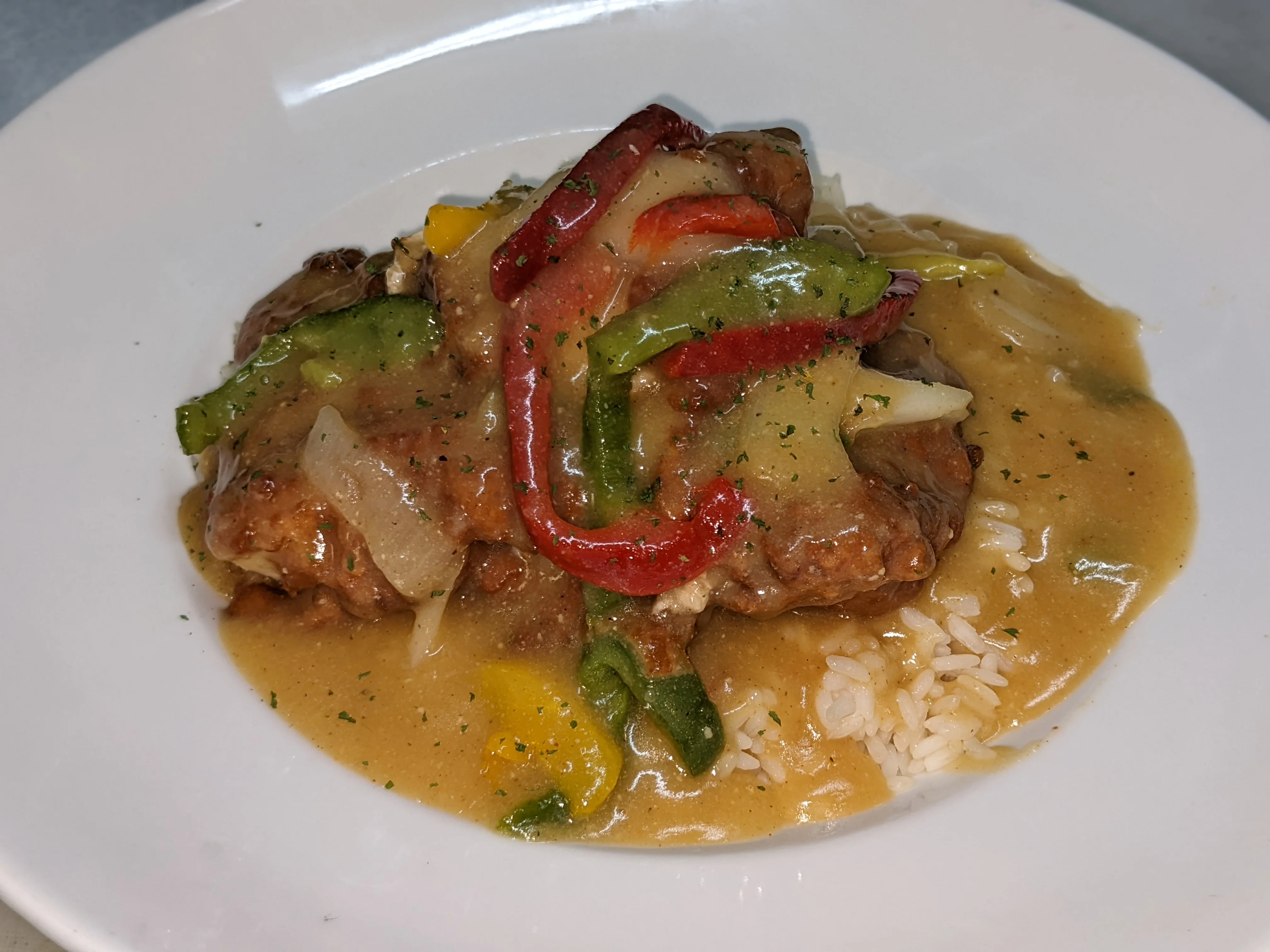 Savory Southern smothered pork chops with peppers and rice