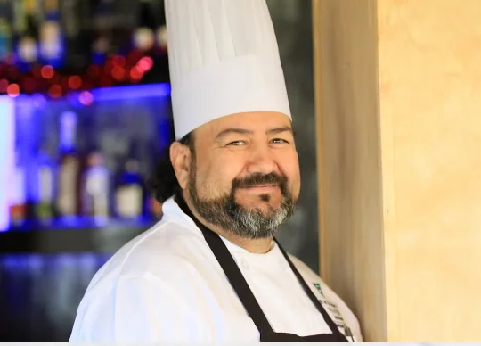 Chef smiling in a professional kitchen setting
