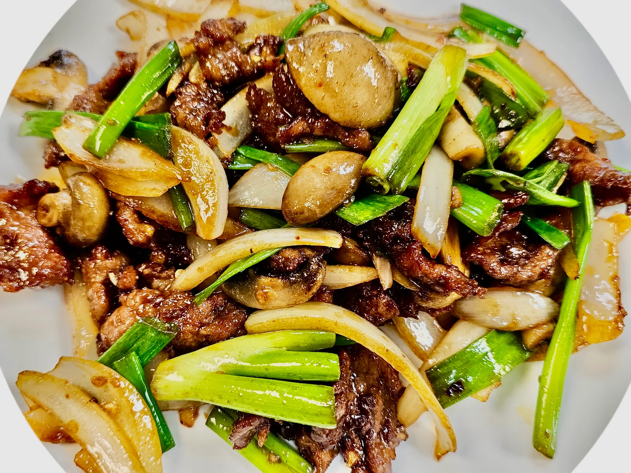 Sizzling Chinese beef stir-fry with green onions and mushrooms