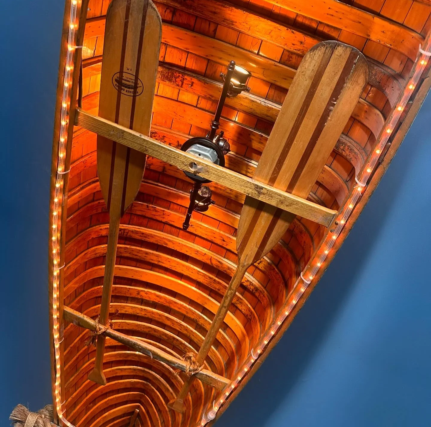 Rustic restaurant ceiling with canoe paddles and warm lighting