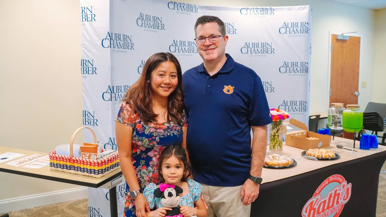 Family posing at Auburn Chamber event with refreshments and decor