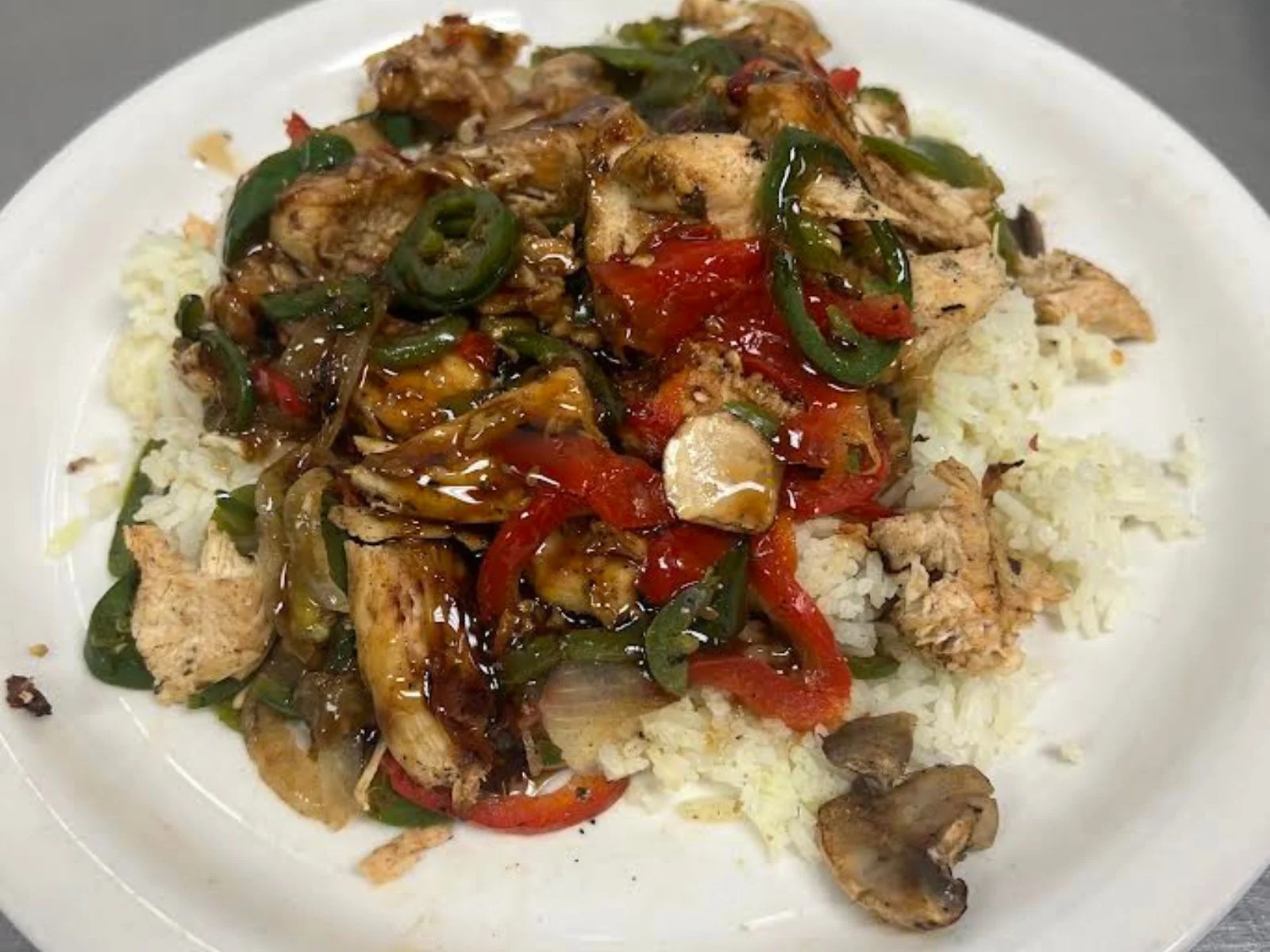 Sizzling chicken stir-fry over rice with colorful vegetables