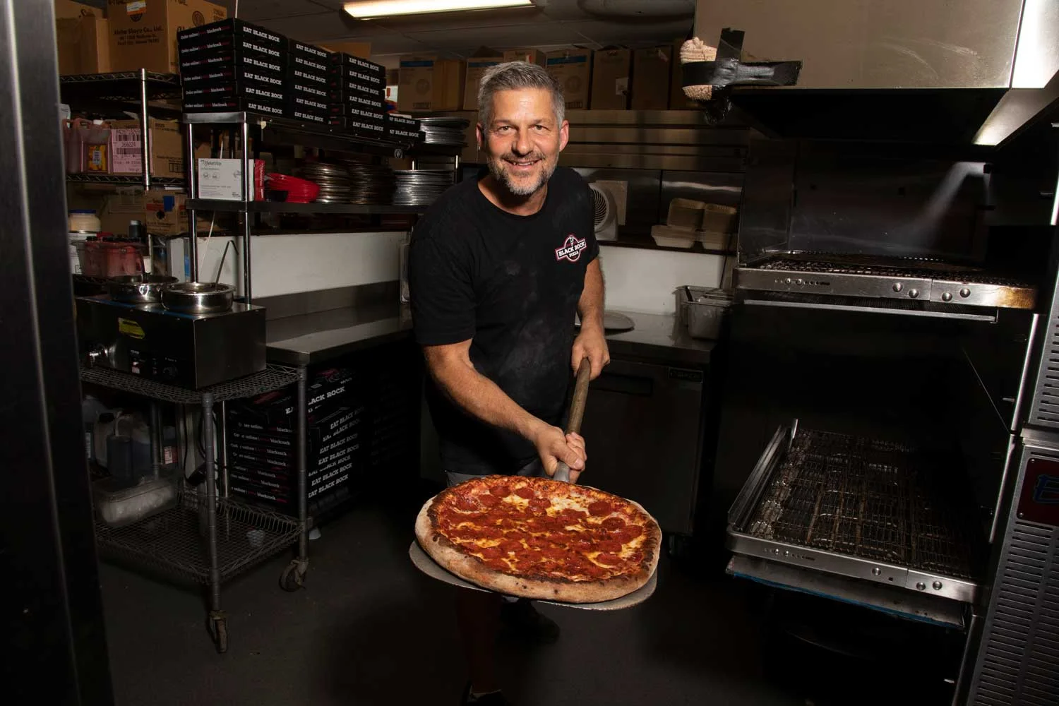 Freshly baked pepperoni pizza being pulled from the oven