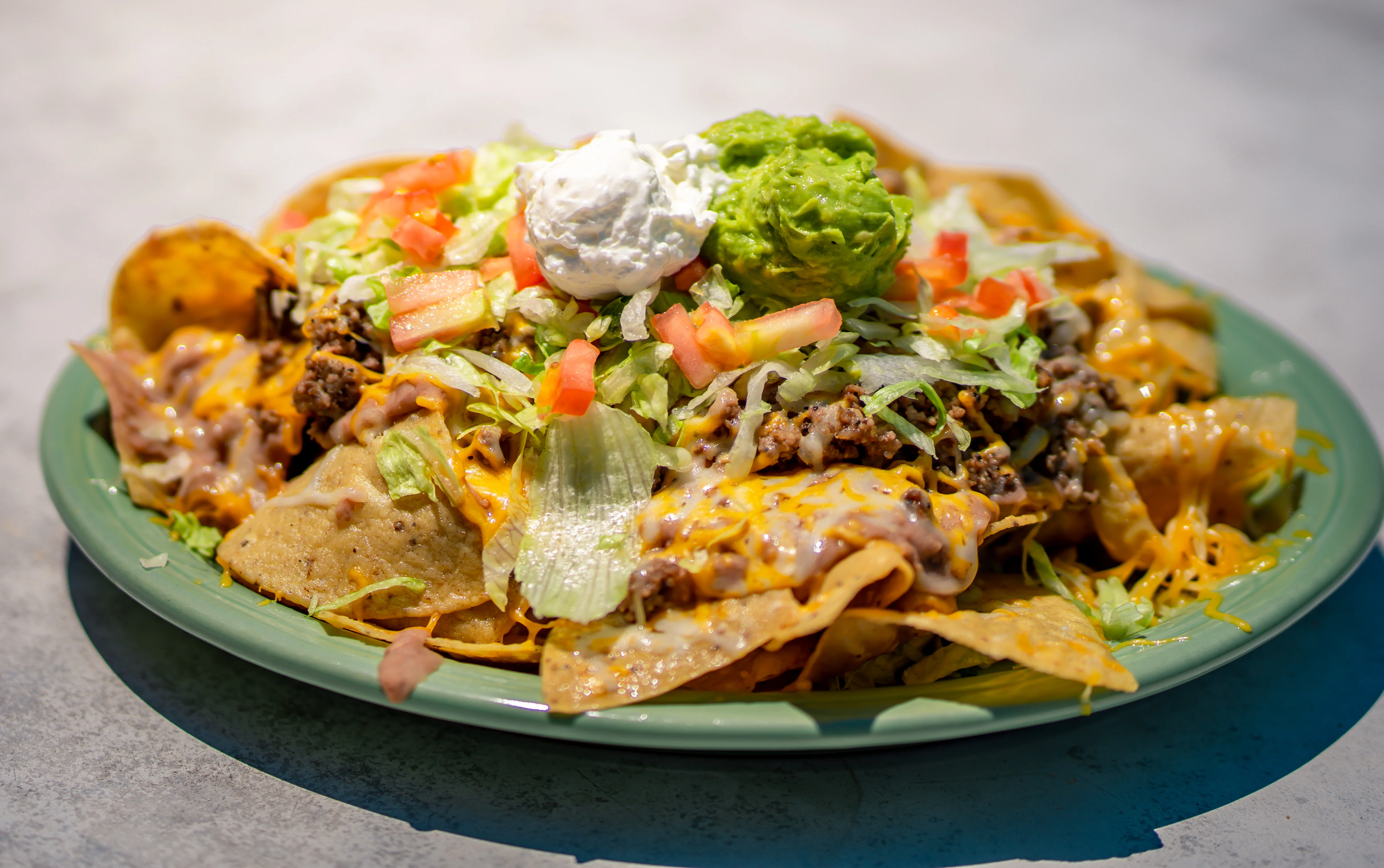 Loaded nachos topped with guacamole and sour cream
