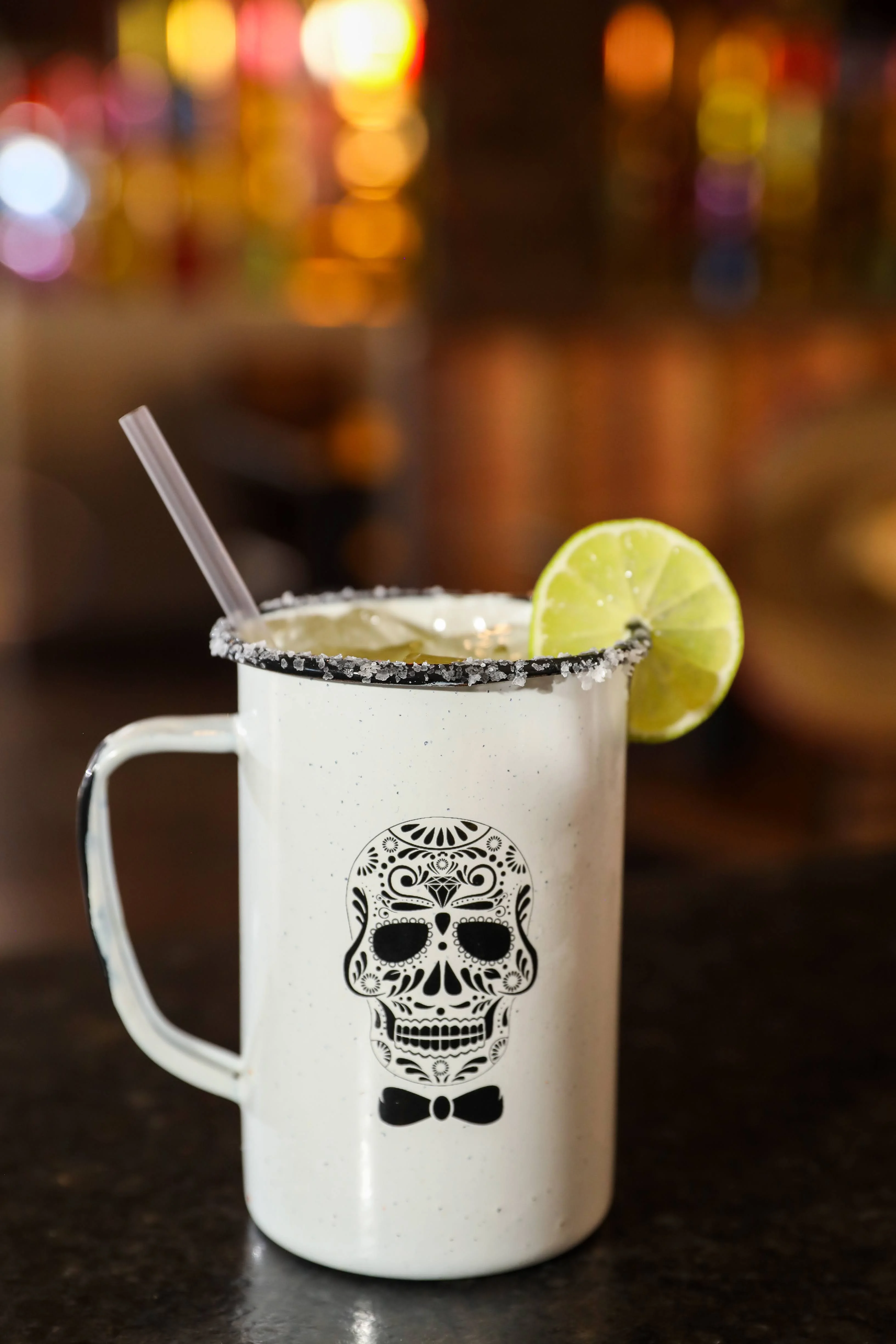 Colorful cocktail in a skull mug with lime garnish