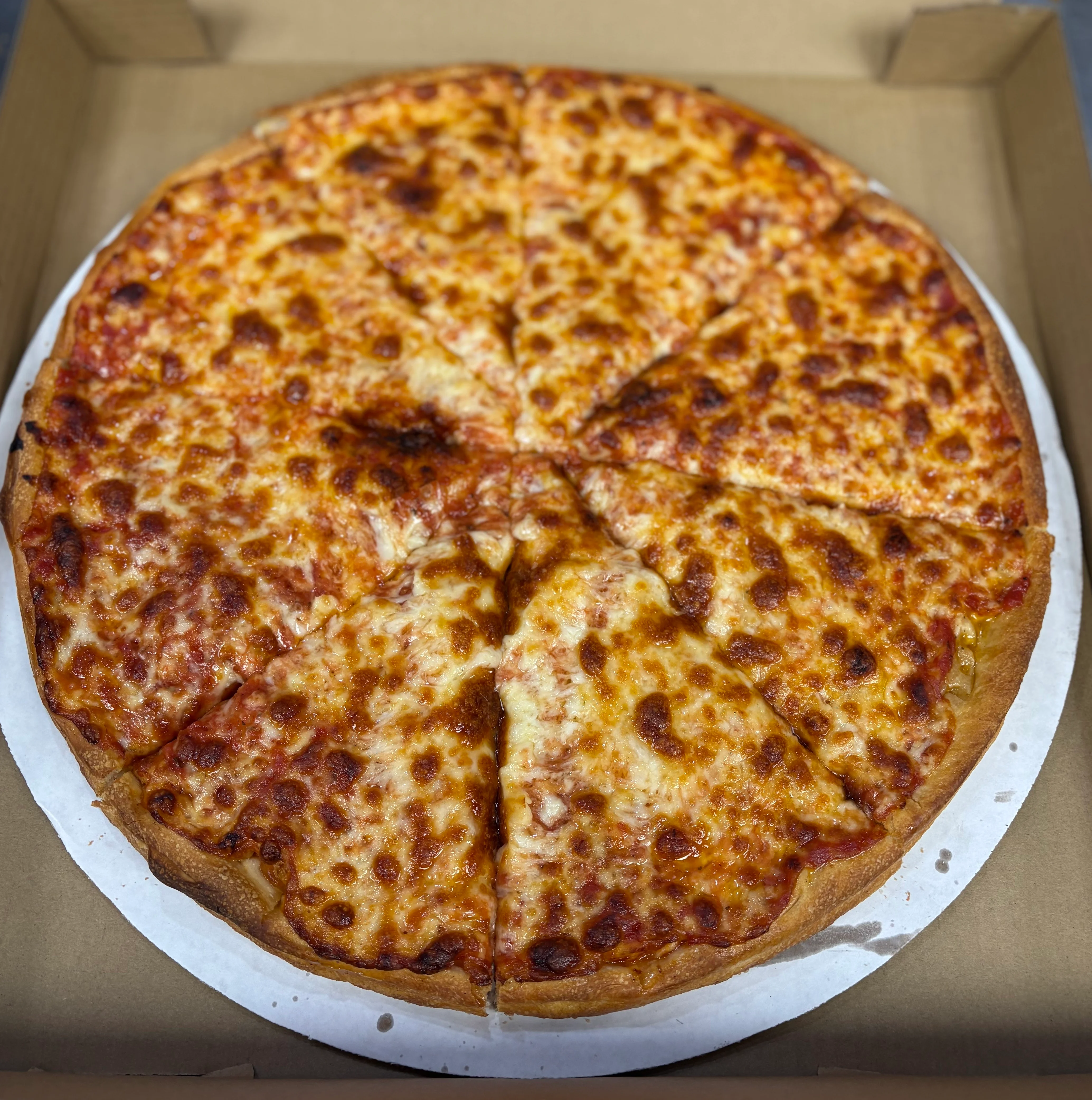 Classic cheese pizza in a takeout box