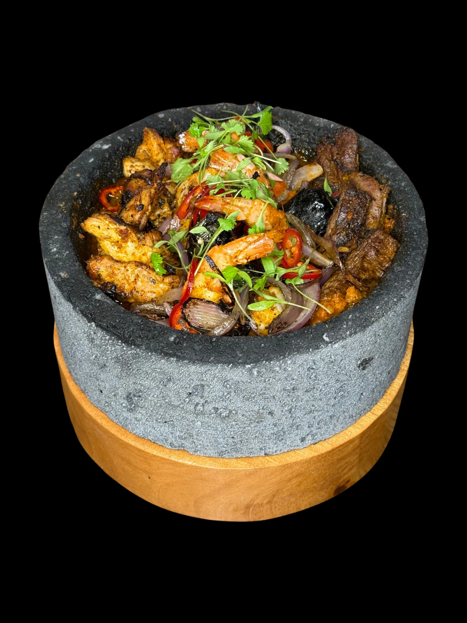 Sizzling mixed grill platter in a hot stone bowl