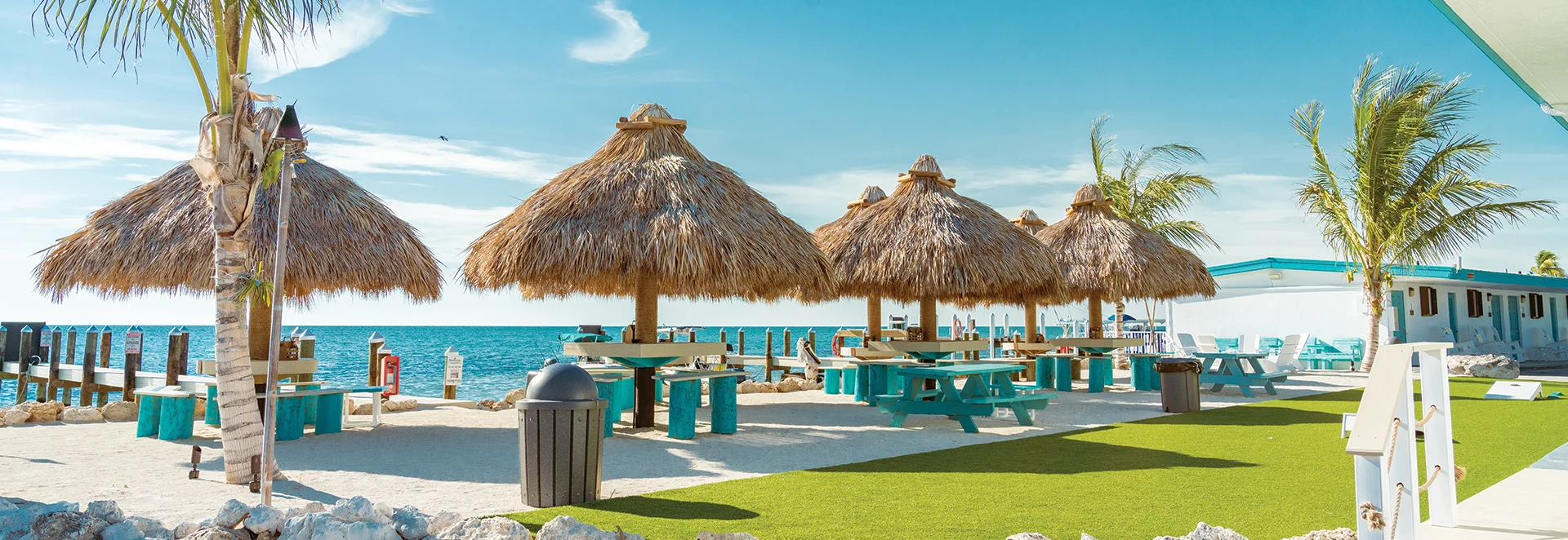 Tropical beachside dining area with thatched umbrellas