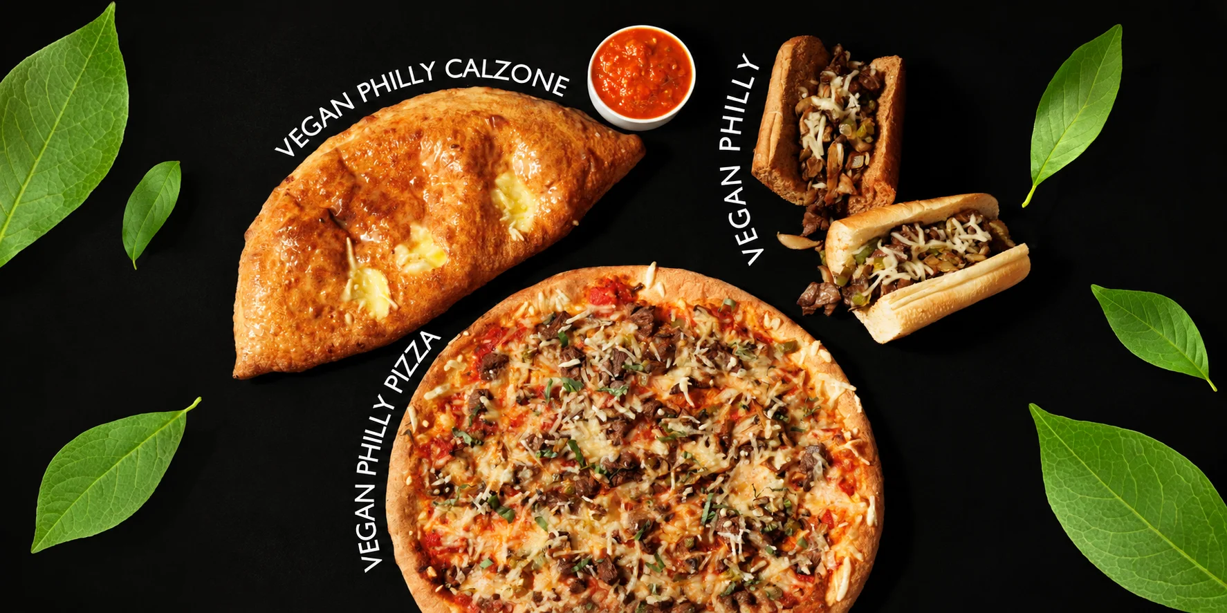 Vegan spread featuring pizzas, calzones, and philly sandwiches