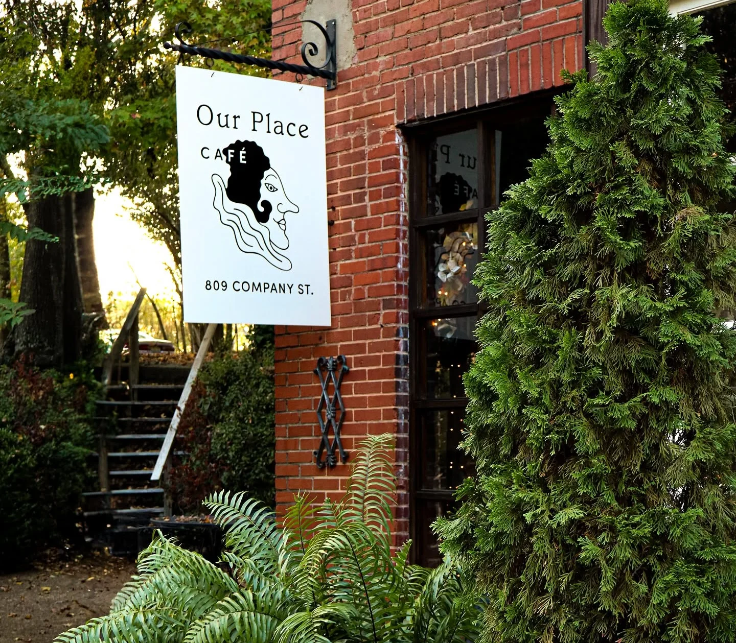 Charming café exterior with greenery and a sign
