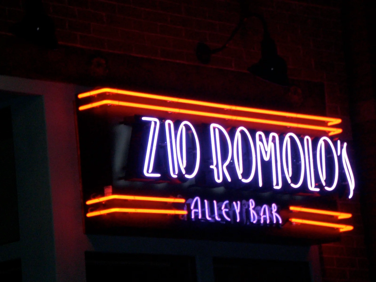 Neon sign of Zio Romolo's Alley Bar at night