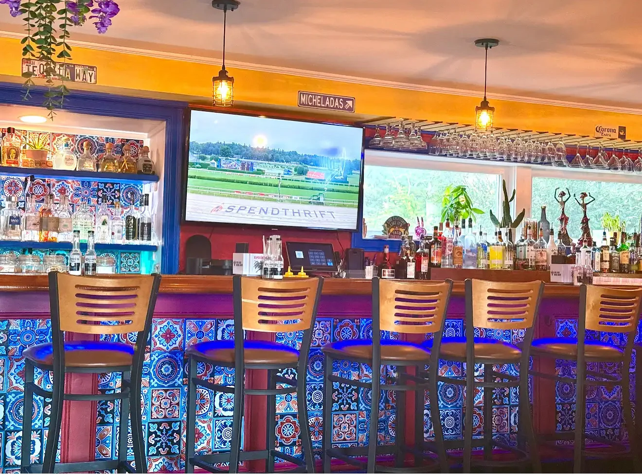 Vibrant bar interior with colorful tiles and a TV screen