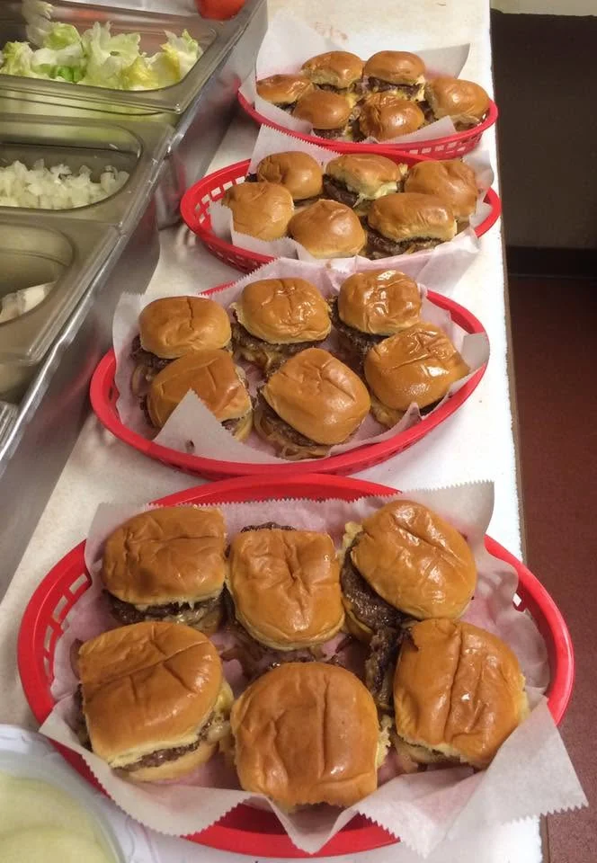 Plates of classic American cheeseburgers in red baskets