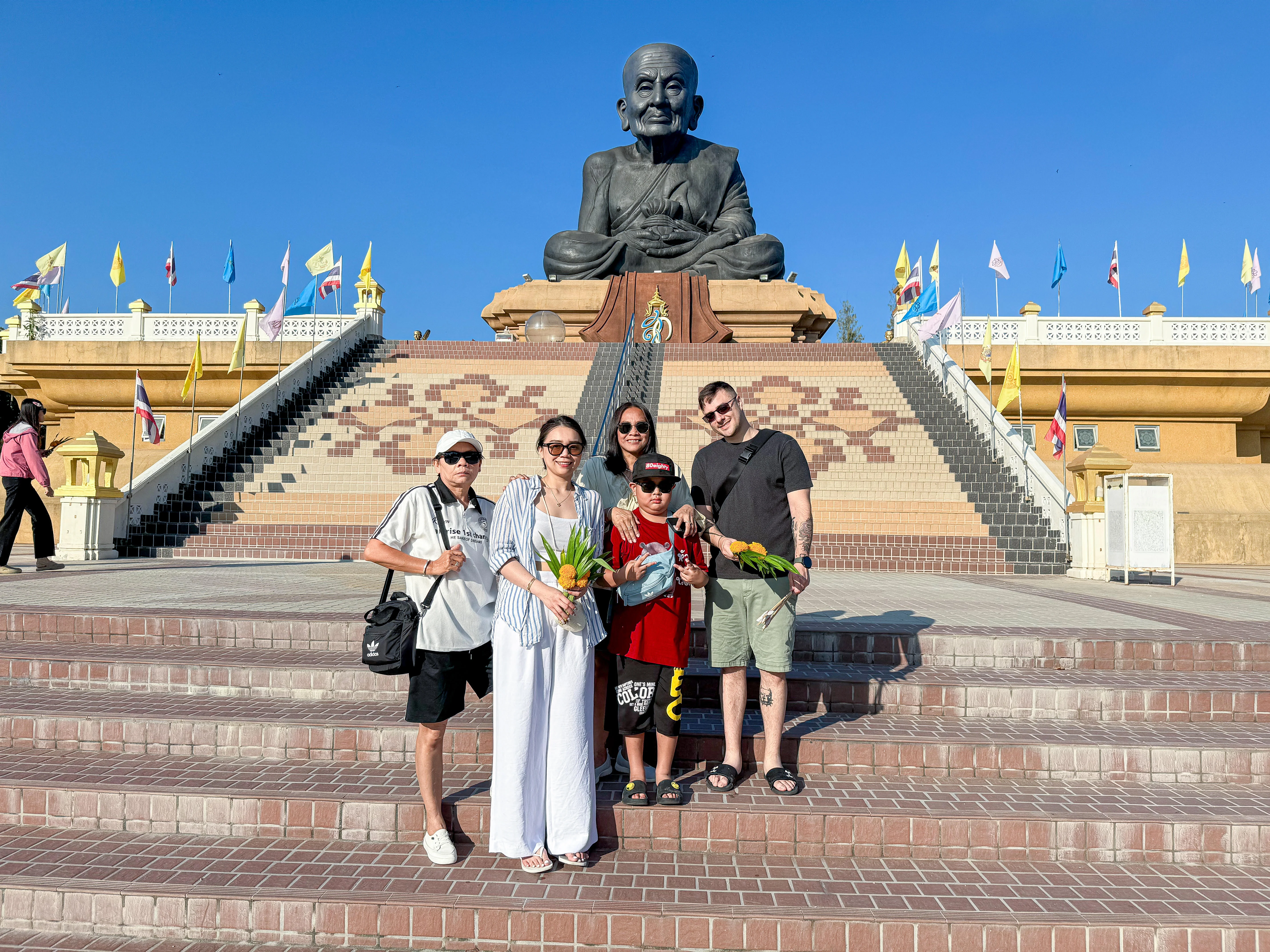 Family standing in front of monk statue