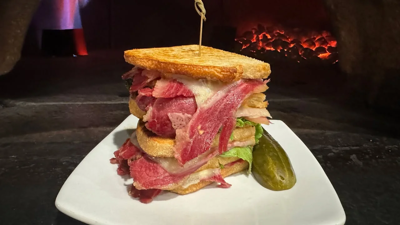 Roast beef sandwich with pickle, photographed in front of the wood fired oven