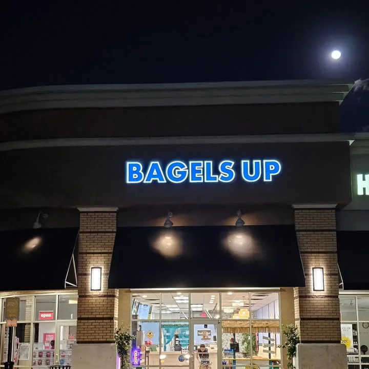 Bagels Up restaurant exterior at night with illuminated sign