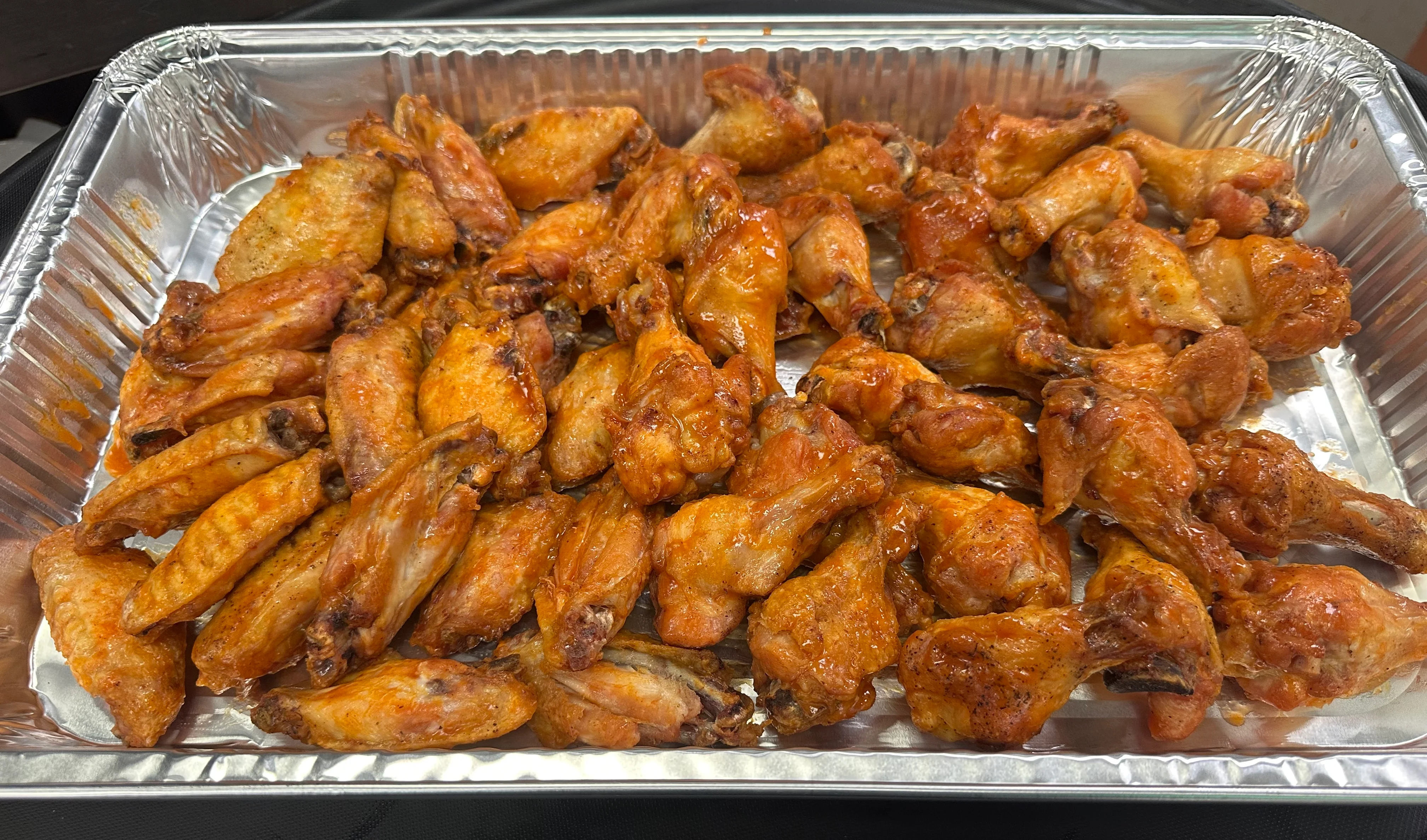 Crispy buffalo chicken wings in a serving tray