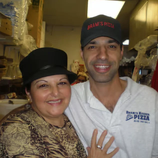 Friendly staff at a pizza restaurant posing for a photo