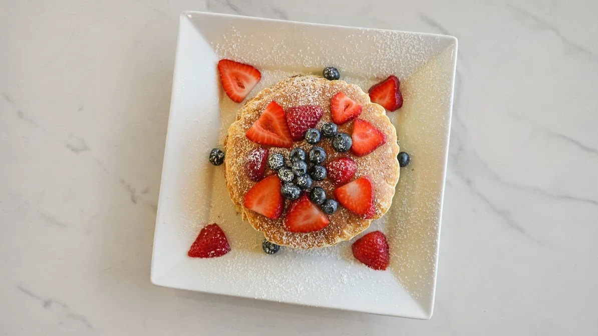 Fluffy pancakes topped with strawberries and blueberries