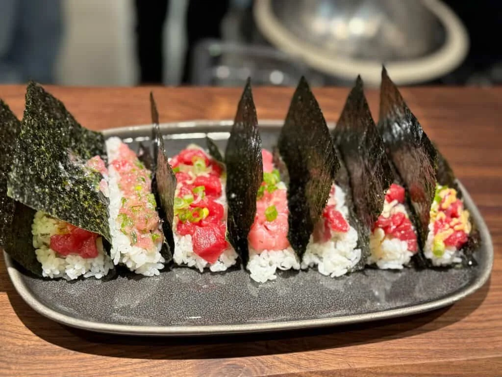 A platter of sushi with various toppings wrapped in seaweed.