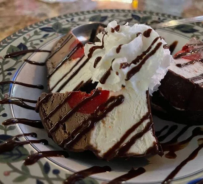 Chocolate mousse cake with whipped cream and chocolate drizzle