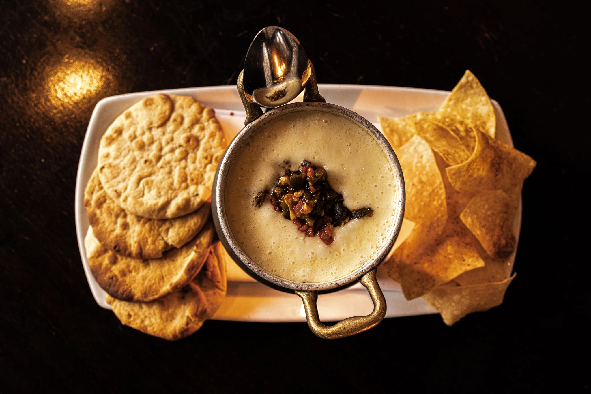 Melted queso fundido served in a skillet with toppings