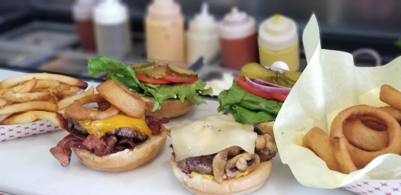 A collection of burgers and a wrap, showcasing different types of bread, toppings, and fillings.
