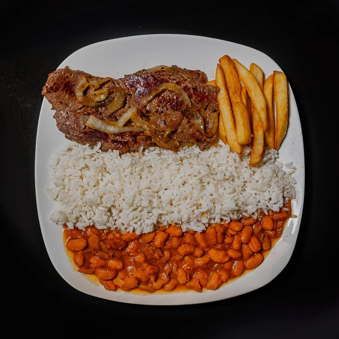 Nigerian jollof rice with grilled steak and plantains