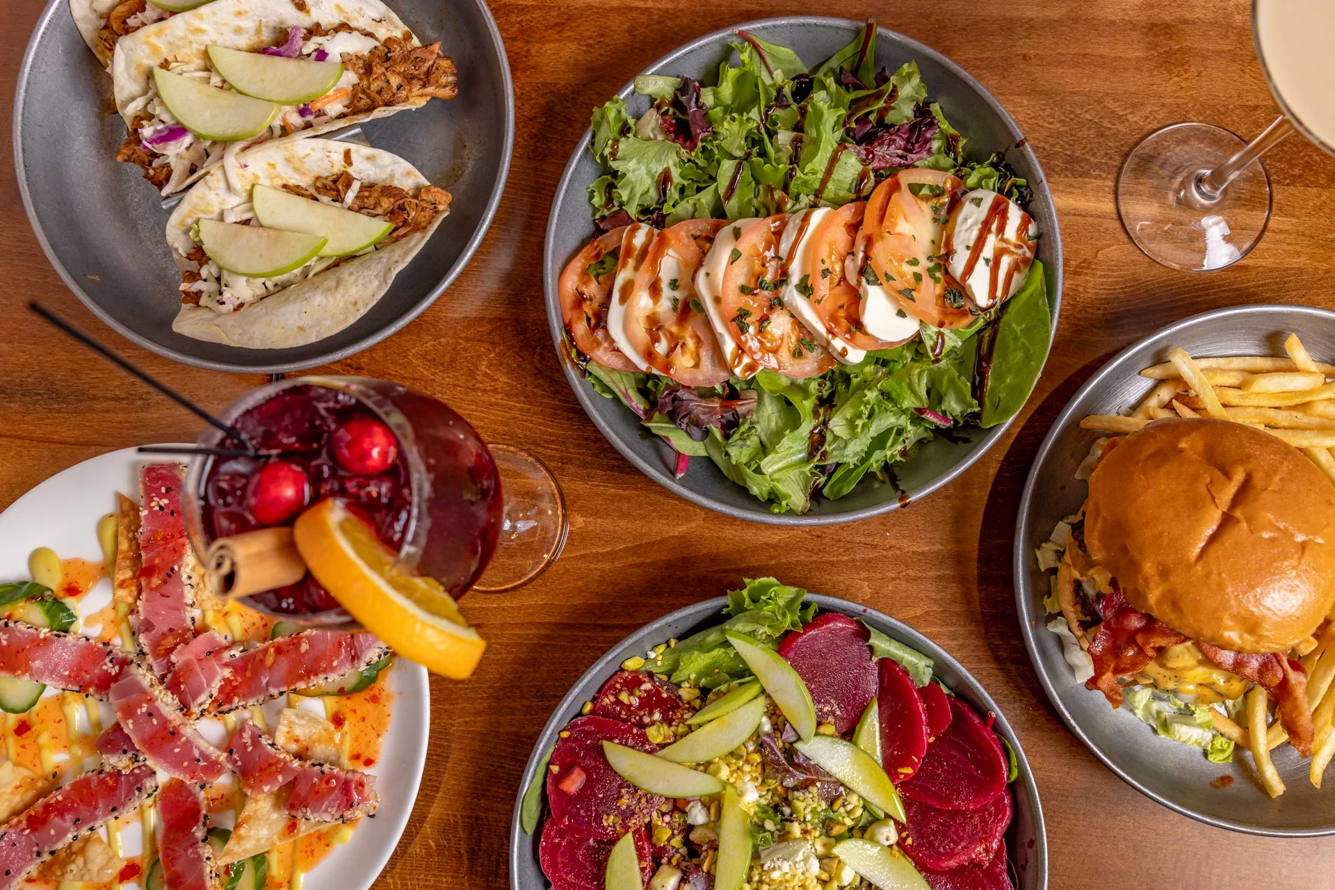 Assorted dishes including tacos and salads in a vibrant restaurant setting