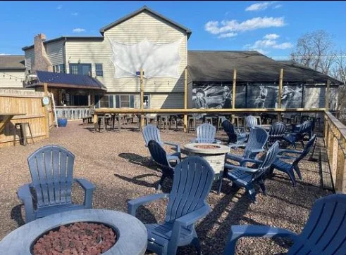 Outdoor dining area with blue chairs and fire pits