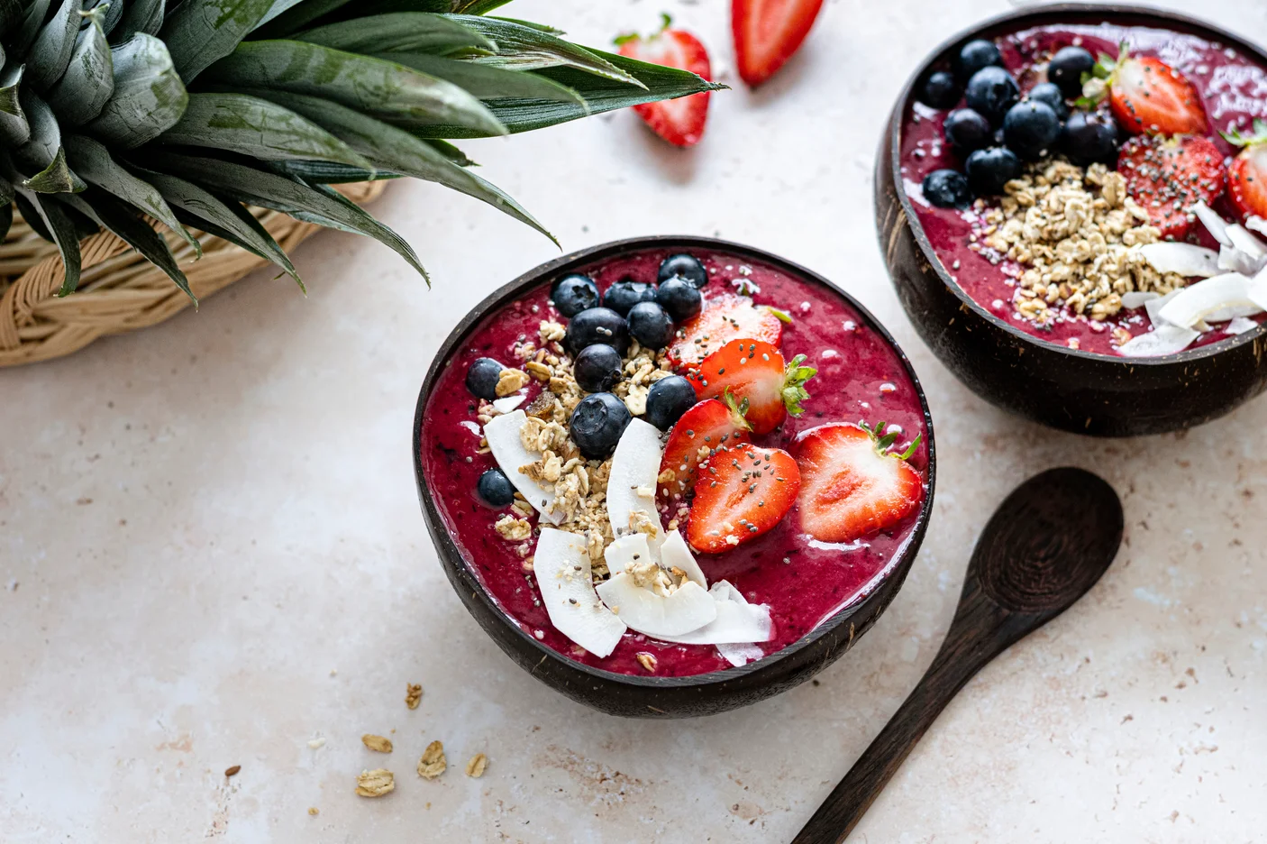 A colorful acai bowl served in a coconut shell with fresh fruits and granola.