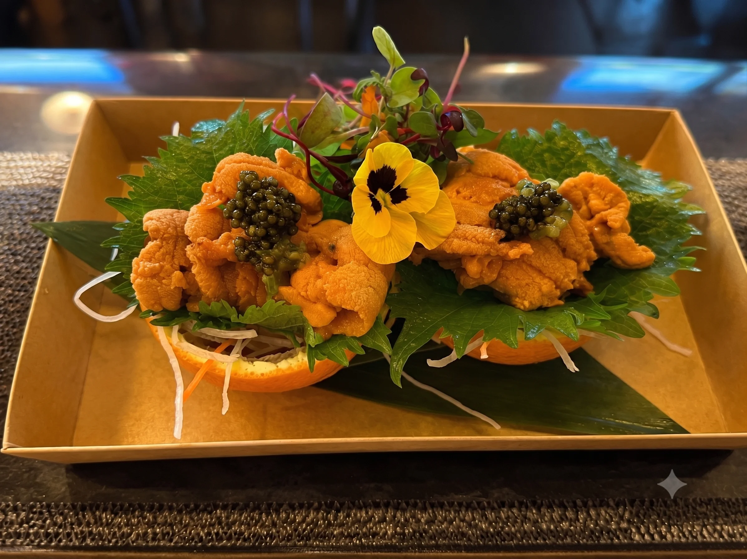 Japanese uni sushi served in orange halves with garnishes