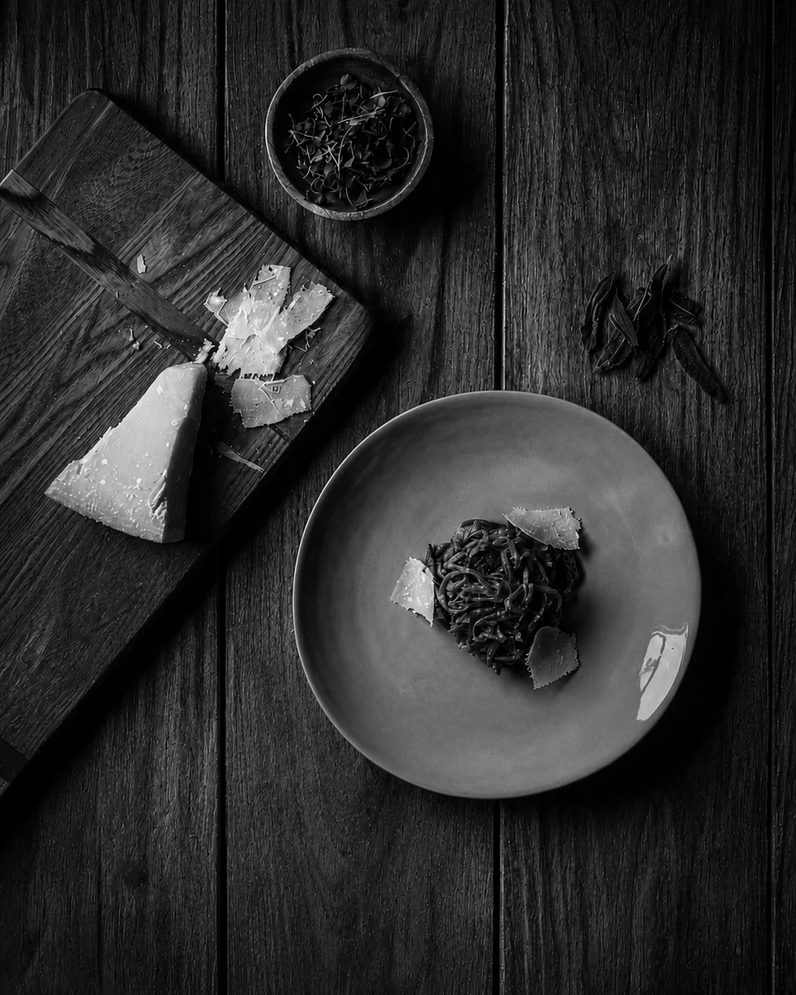 Black spaghetti dish with cheese and herbs