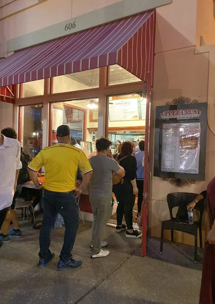 Busy restaurant entrance with patrons waiting outside