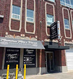 Exterior view of a pizzeria with a vintage brick facade