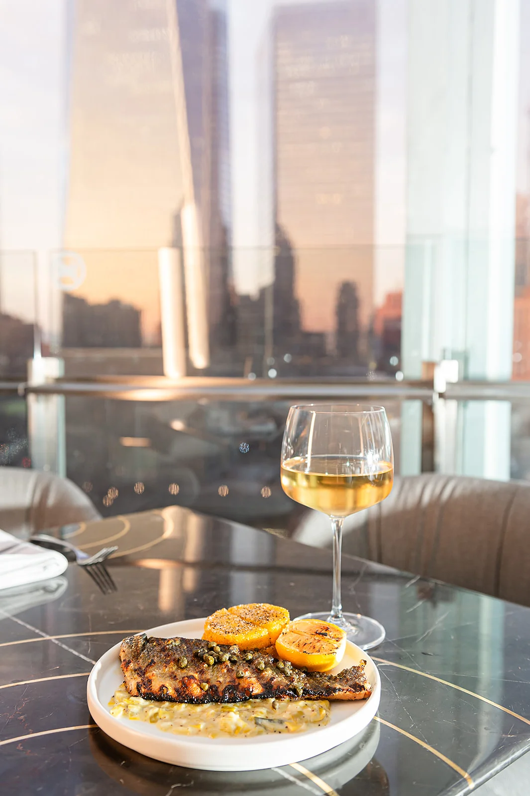 Grilled fish with lemon and capers in a modern dining setting