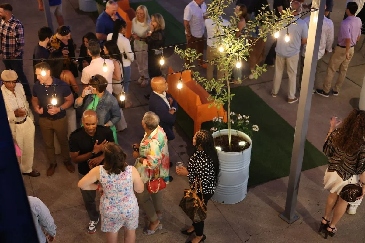 A lively outdoor gathering with people socializing under string lights.