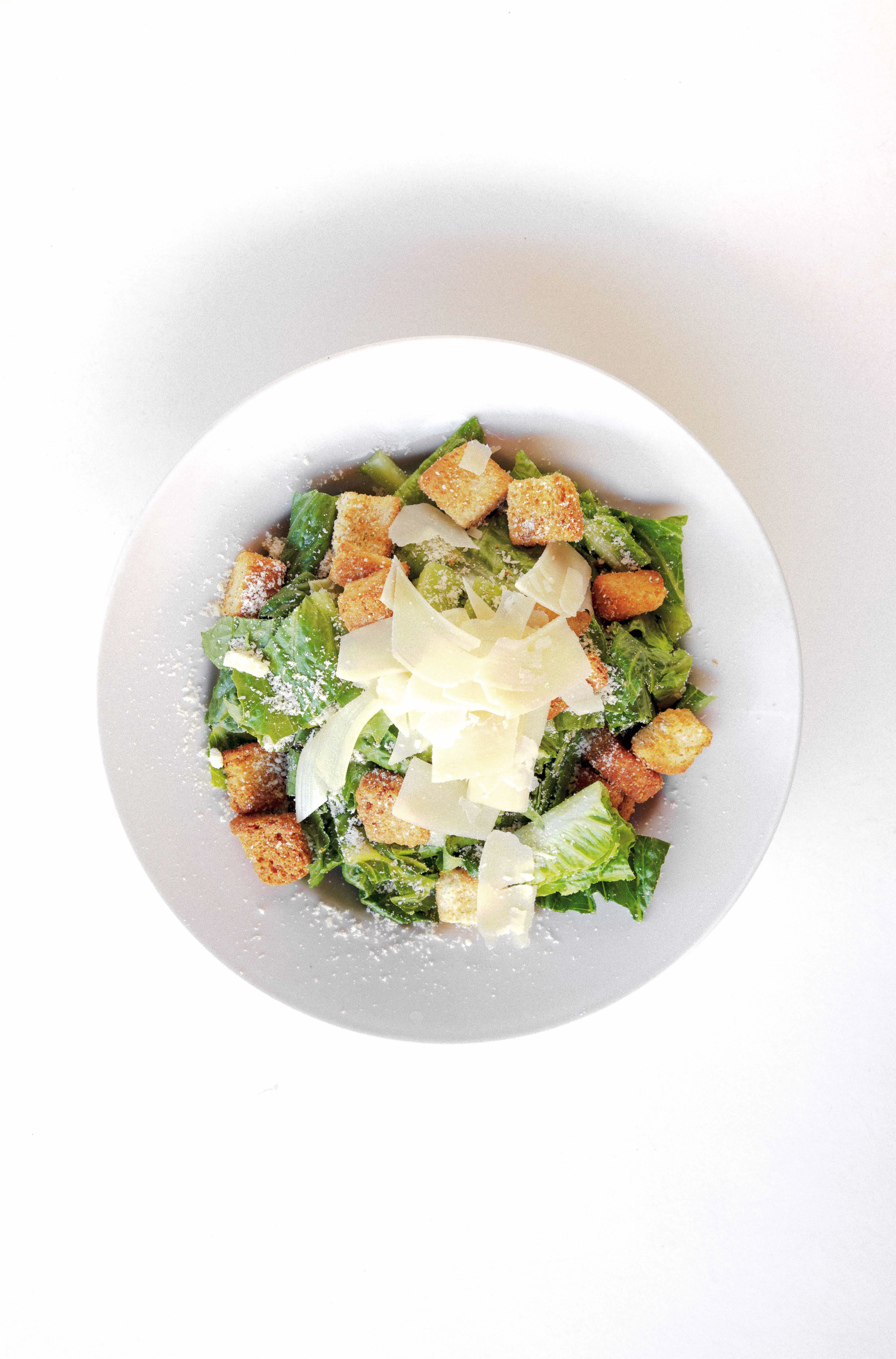 classic caesar salad with croutons and cheese on clean white table