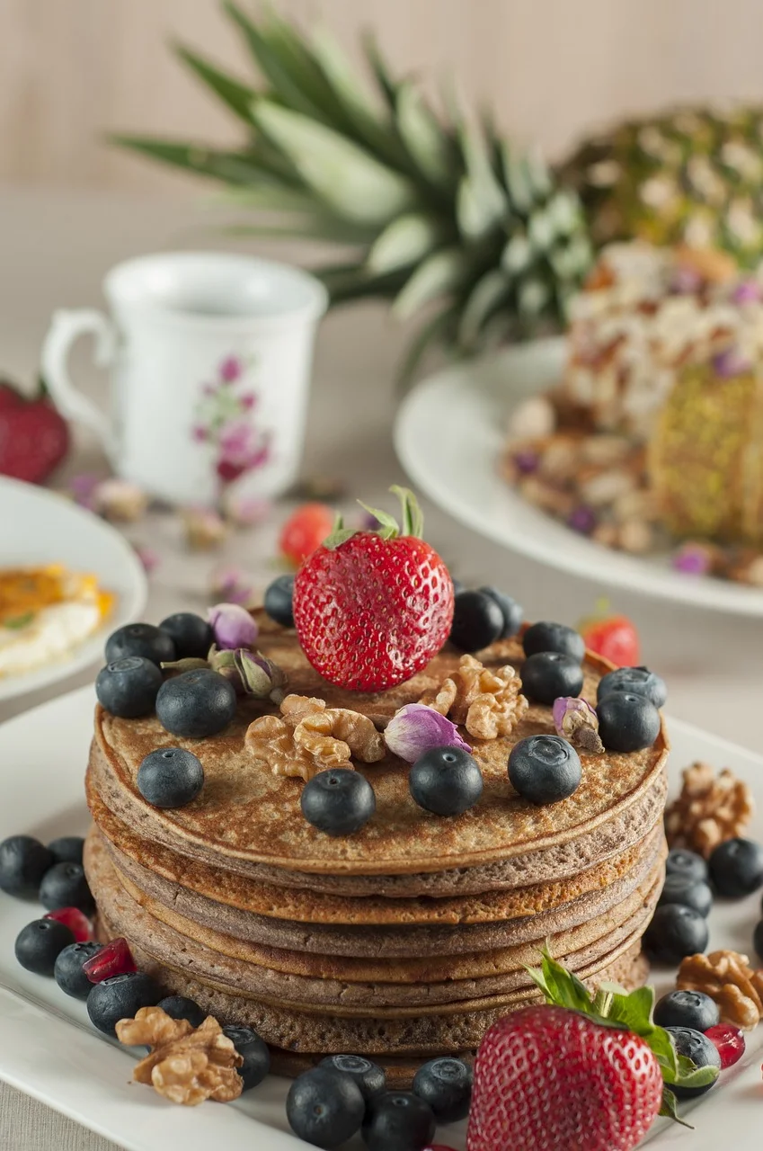Fluffy pancakes topped with berries and walnuts